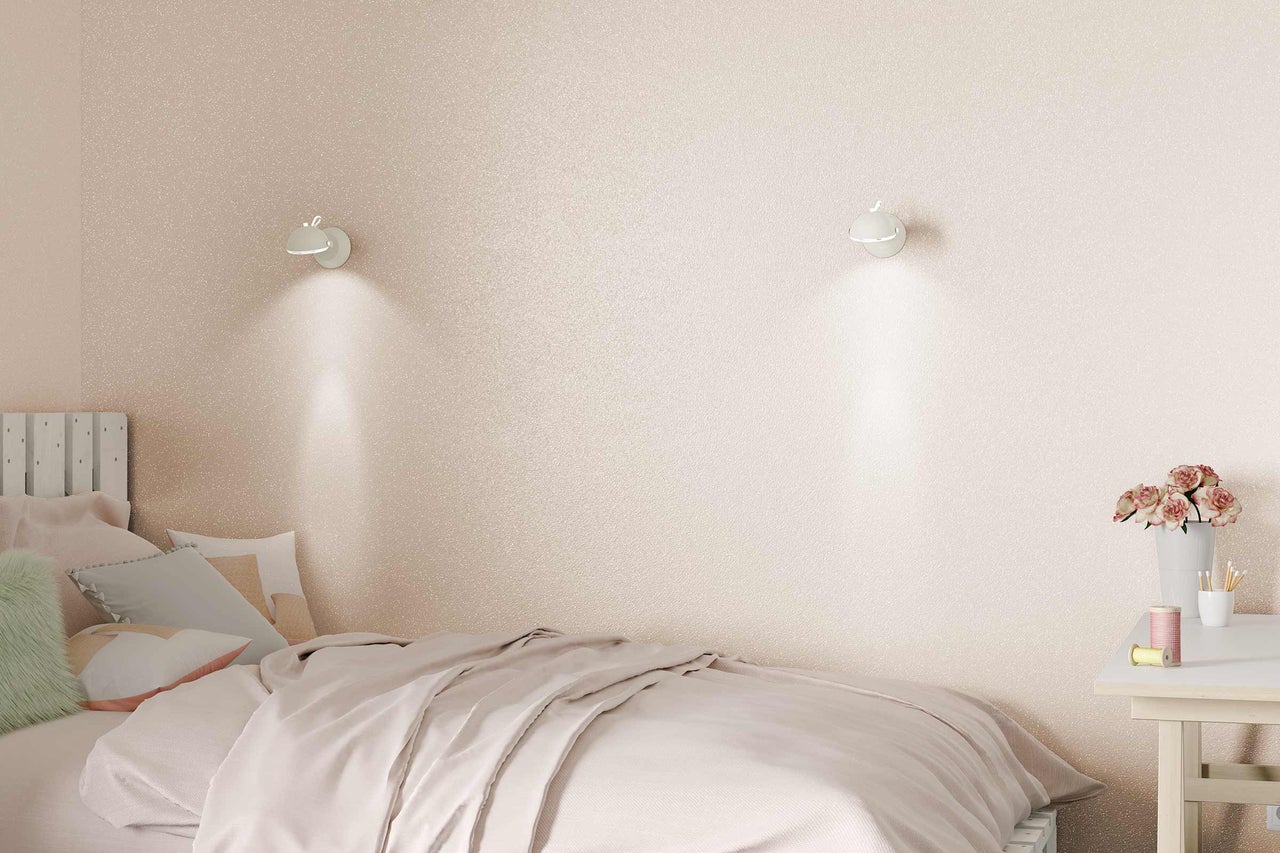 Slaapkamer met bed, nachtkastje en wandlampen voor glinsterend behang
