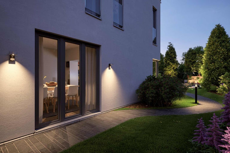 Verlicht huis met tuinpad en buitenlampen