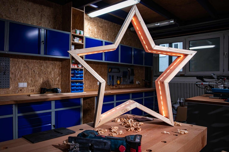 Decoratieve houten ster met verlichting in een werkplaats