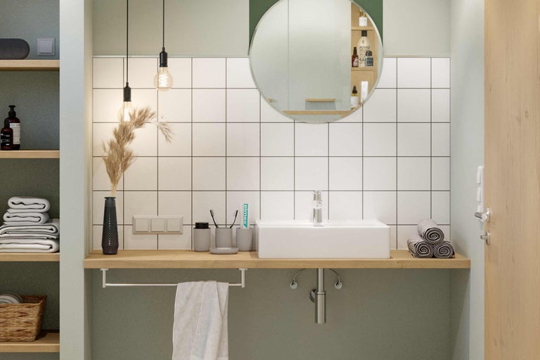 Badkamer met wastafel, spiegel en handdoeken.