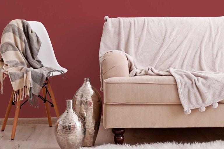 Decoratieve woonomgeving met bank, stoel, dekens en vazen