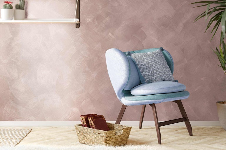 Woonkamer met fauteuil, kussens en decoratie op plank en vloer