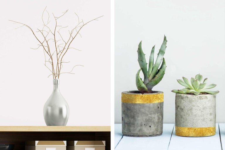 Decoratieve scène met vaas en takken en twee vetplanten in betonnen bloempotten.