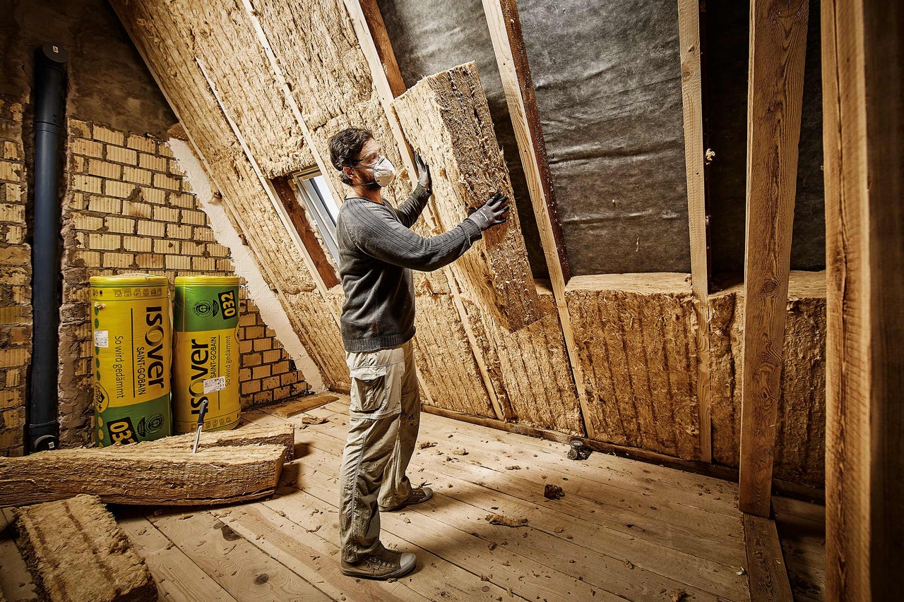 Zolderisolatie met Isover isolatiewol door een persoon.