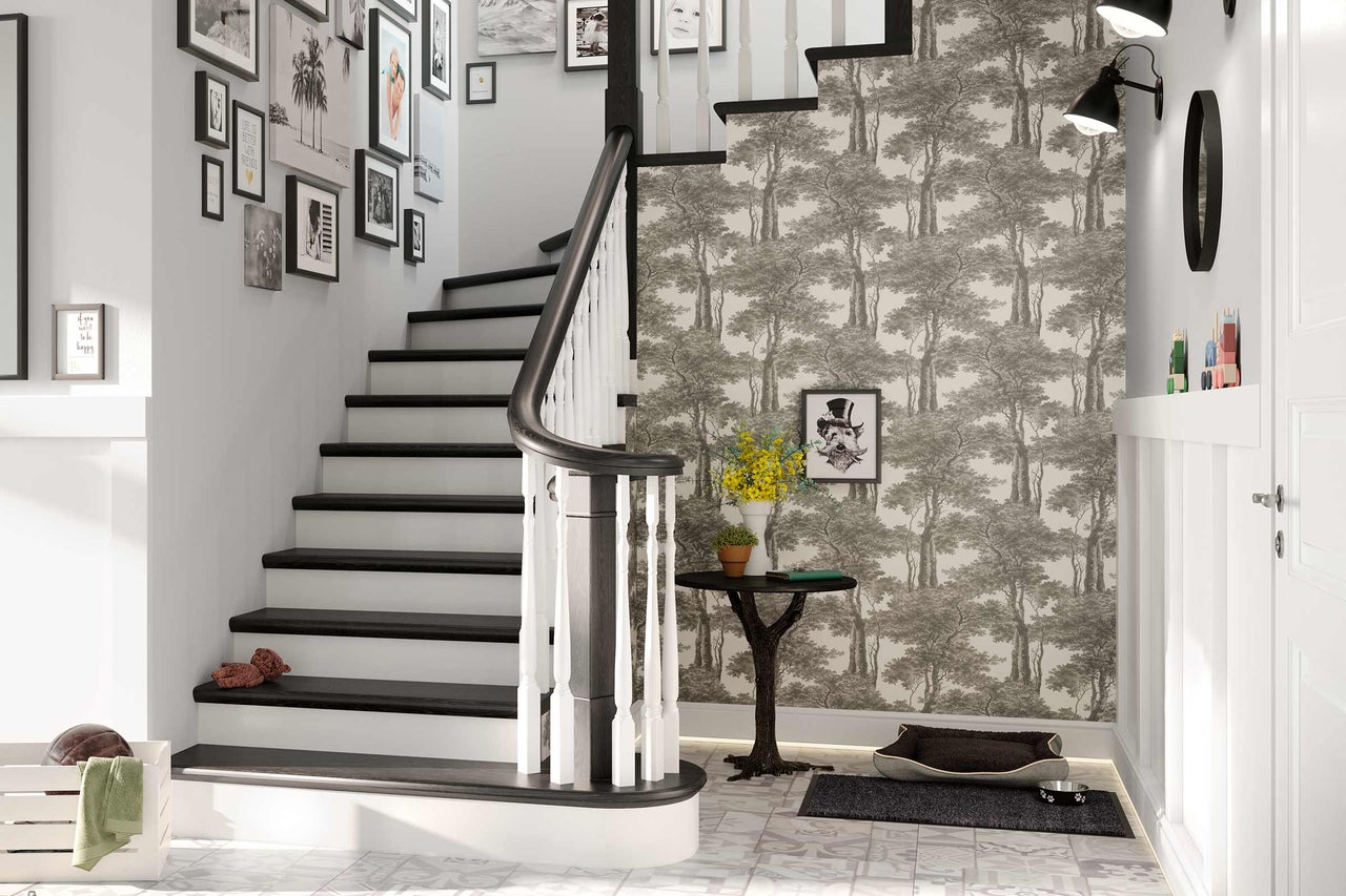 Hal met trap, fotowand, behang met patroon en decoraties.