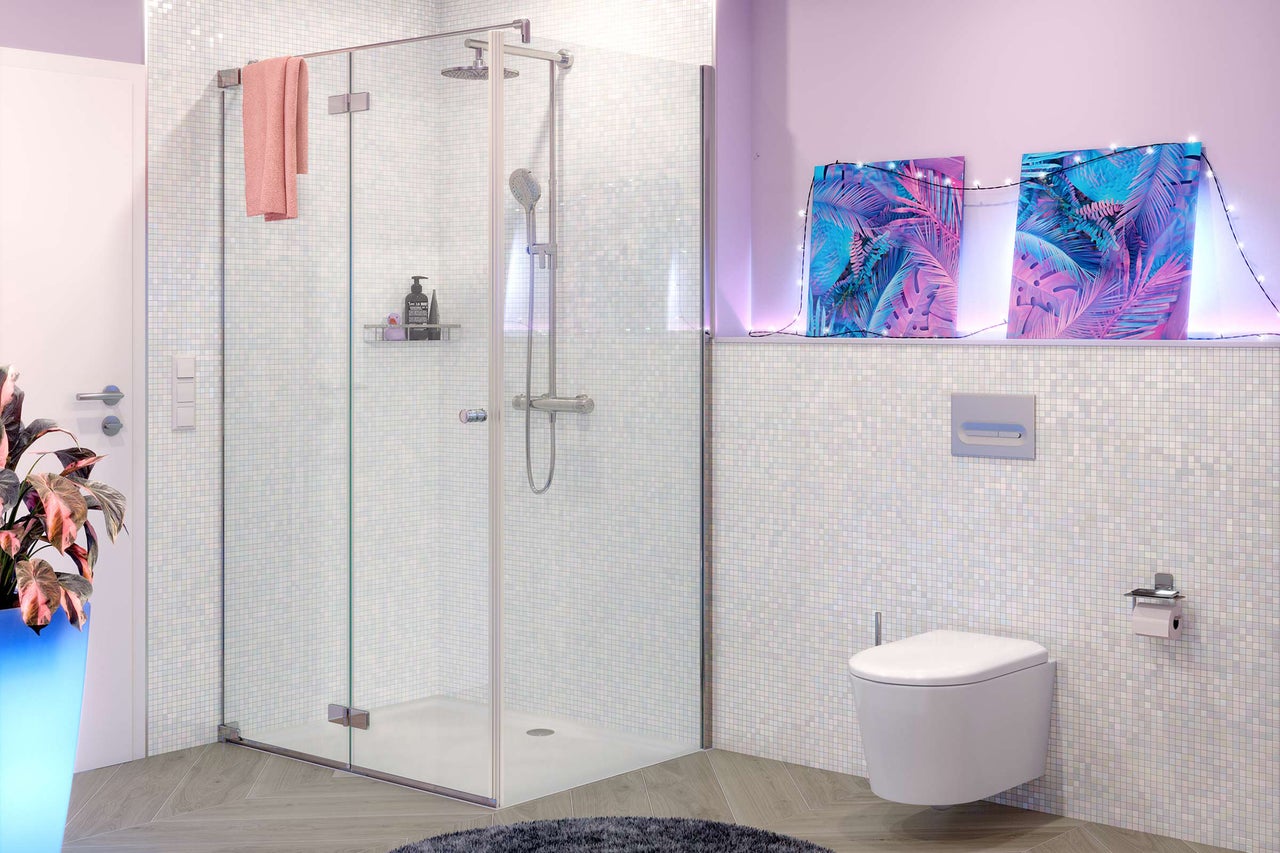 Moderne badkamer met glazen douchecabine, regendouche, hangtoilet en lichtgekleurde mozaïektegels.