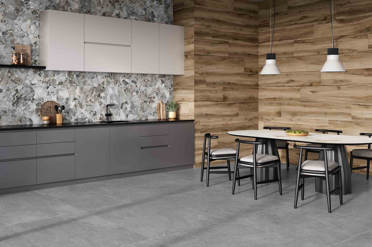 Lichte, ruime keuken met grijze tegelvloer, werkblad, achterwand en houten wand