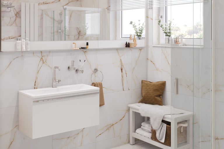 Lichte badkamer met wastafel, spiegel, handdoekhouder en bank voor een marmeren wand