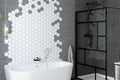 Badkamer met vrijstaand bad, douchecabine en zeshoekige wandtegels Badkamer met vrijstaand bad, douchecabine en zeshoekige wandtegels