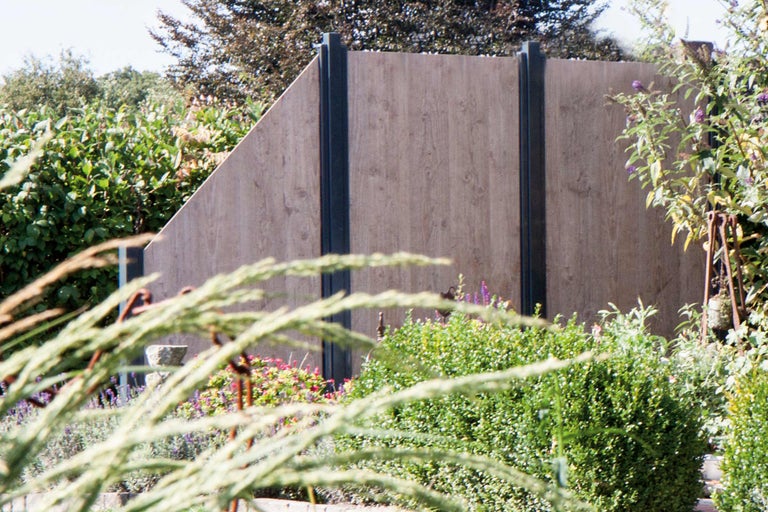 Houten schutting in een tuin met planten