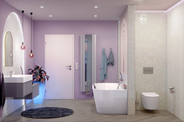 Moderne badkamer met lavendelkleurige muren, vrijstaand bad, hangend toilet, grijs wastafelmeubel en vloer met houtlook.