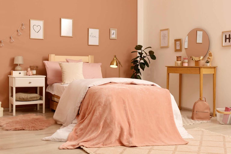 Lichte slaapkamer met bed, nachtkastje en commode in modern design.