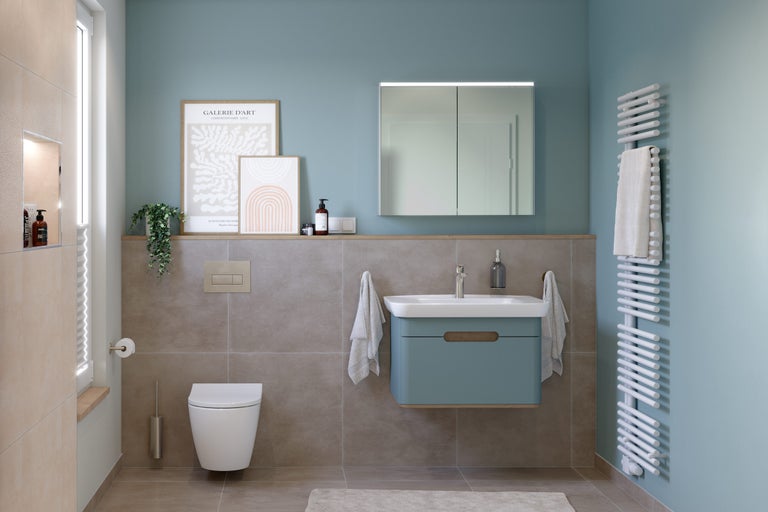 Lichte badkamer met toilet, wastafel, spiegelkast en radiator