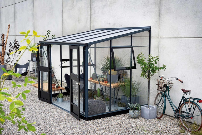 Tuinkas met planten en tuindecoratie in buitenruimte.
