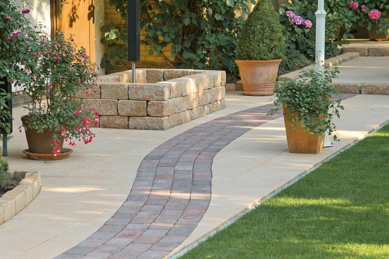 Tuinpad met bestrating, muur en potplanten