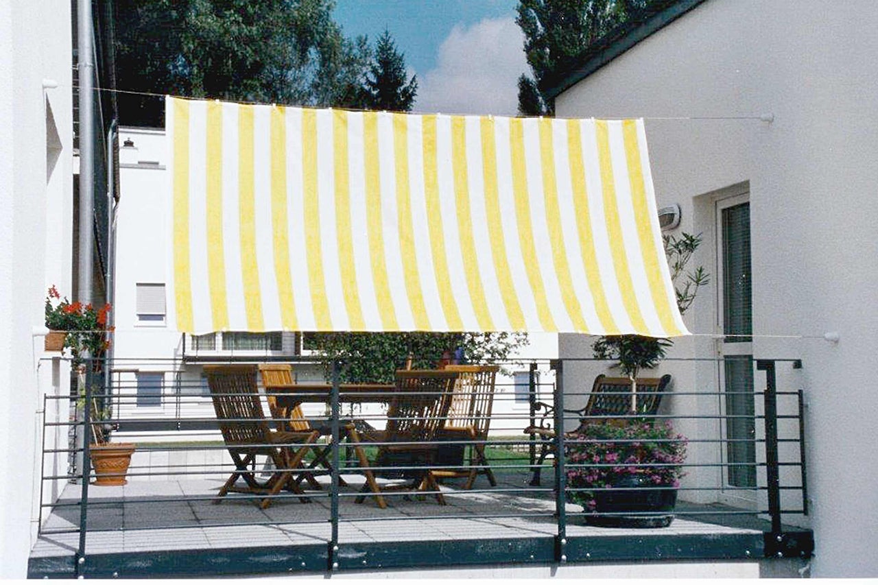 Balkon met luifel, tafel en stoelen voor buiten.