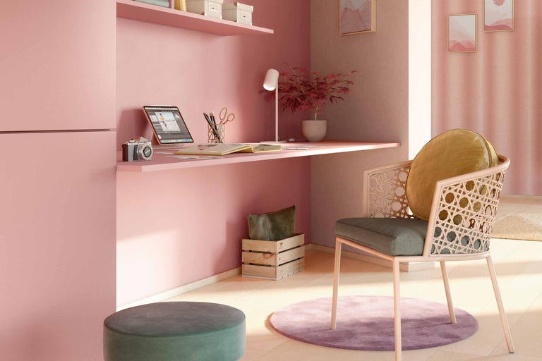 Een werkkamer met bureau, stoel, lamp en decoraties.