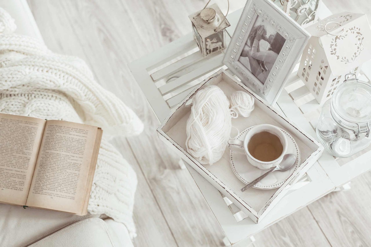Decoratieve scène met boek, deken, bijzettafel en theekop voor een gezellige sfeer