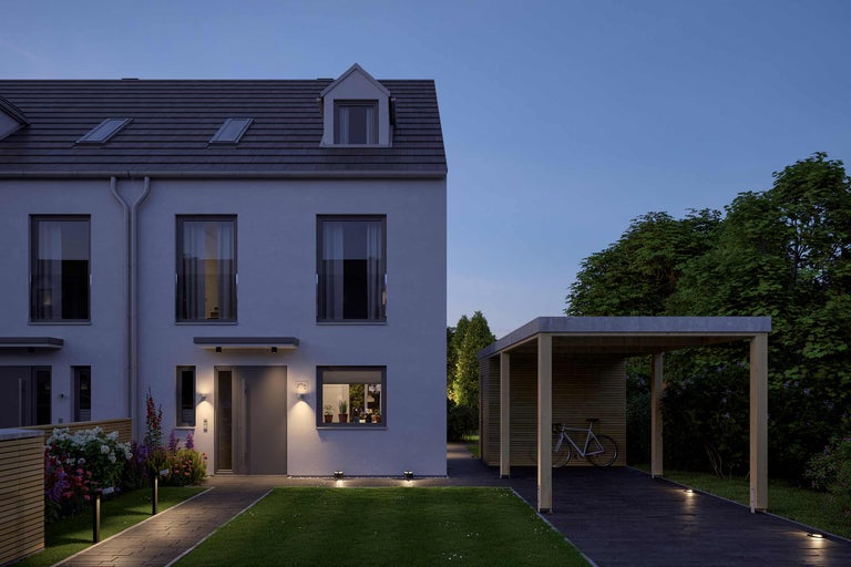 Buitenaanzicht van een modern rijtjeshuis met carport in de schemering