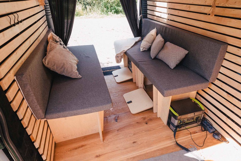 Interieur van een omgebouwde bestelwagen met zithoek en houten wanden