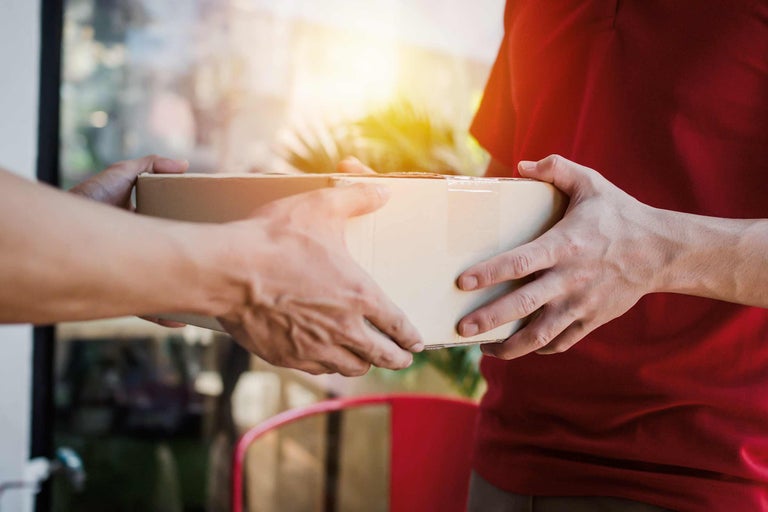 Pakketbezorger overhandigt een pakket