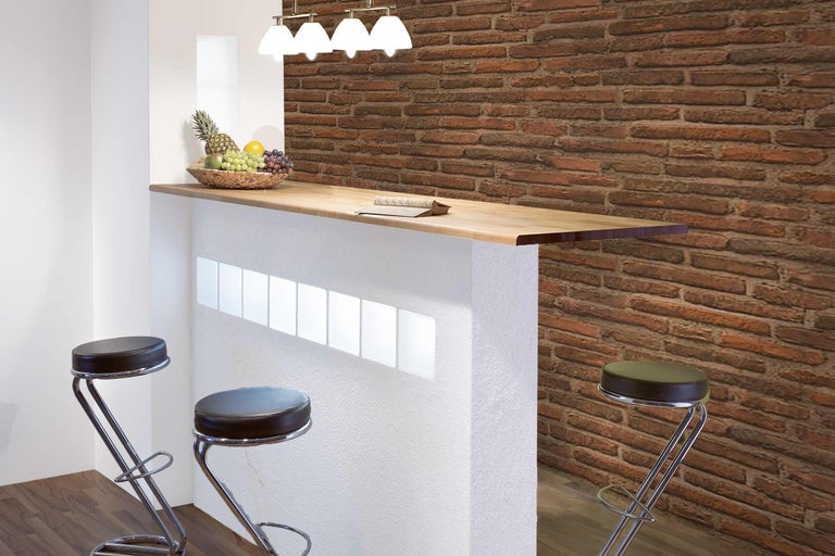 Bar met houten blad, barkrukken en bakstenen muur