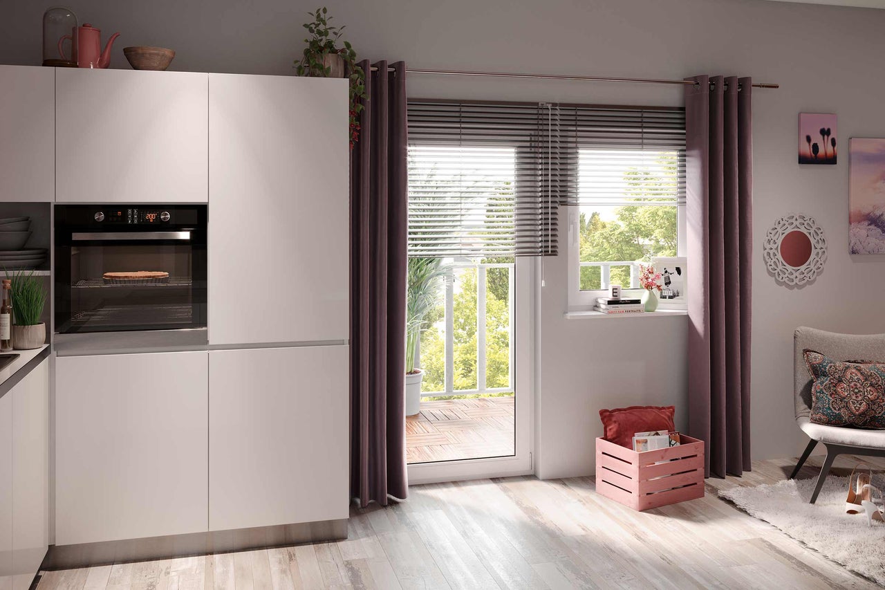 Lichte keuken met inbouwoven, raam naar balkon en decoraties