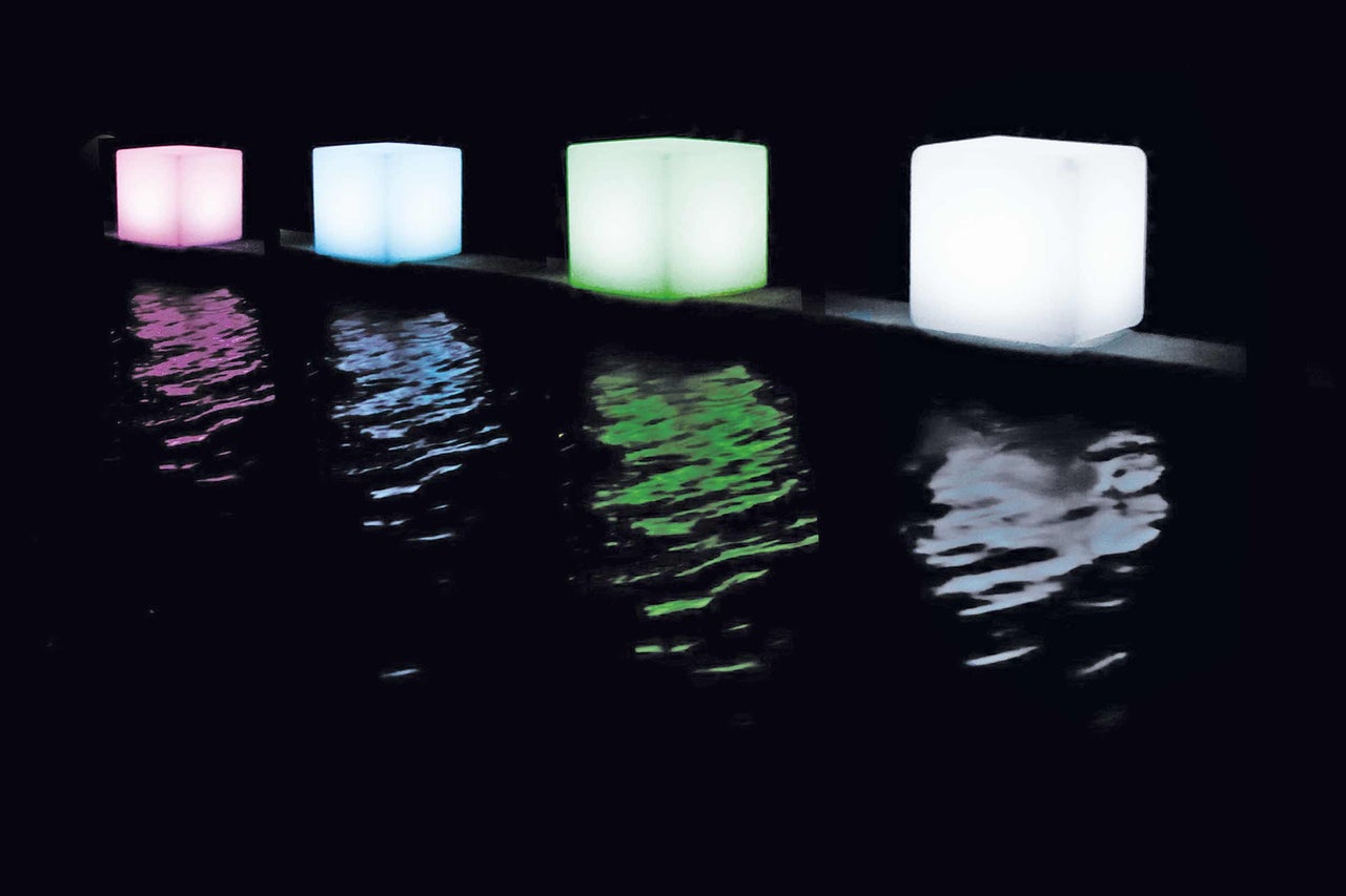 Rij van lichtgevende kubussen als decoratie voor buiten met waterspiegeling
