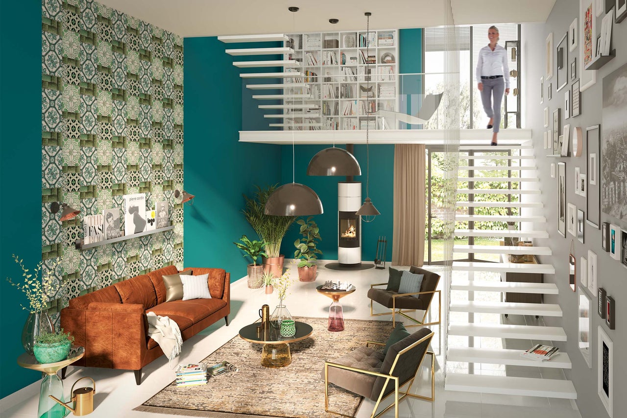 Lichte woonkamer met bank, open haard, trap, decoratie en boekenkast voor een moderne woonomgeving.