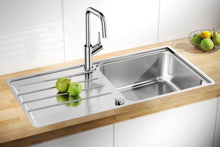Roestvrijstalen spoelbak met afdruiprek en eenhendelmengkraan in een moderne keuken