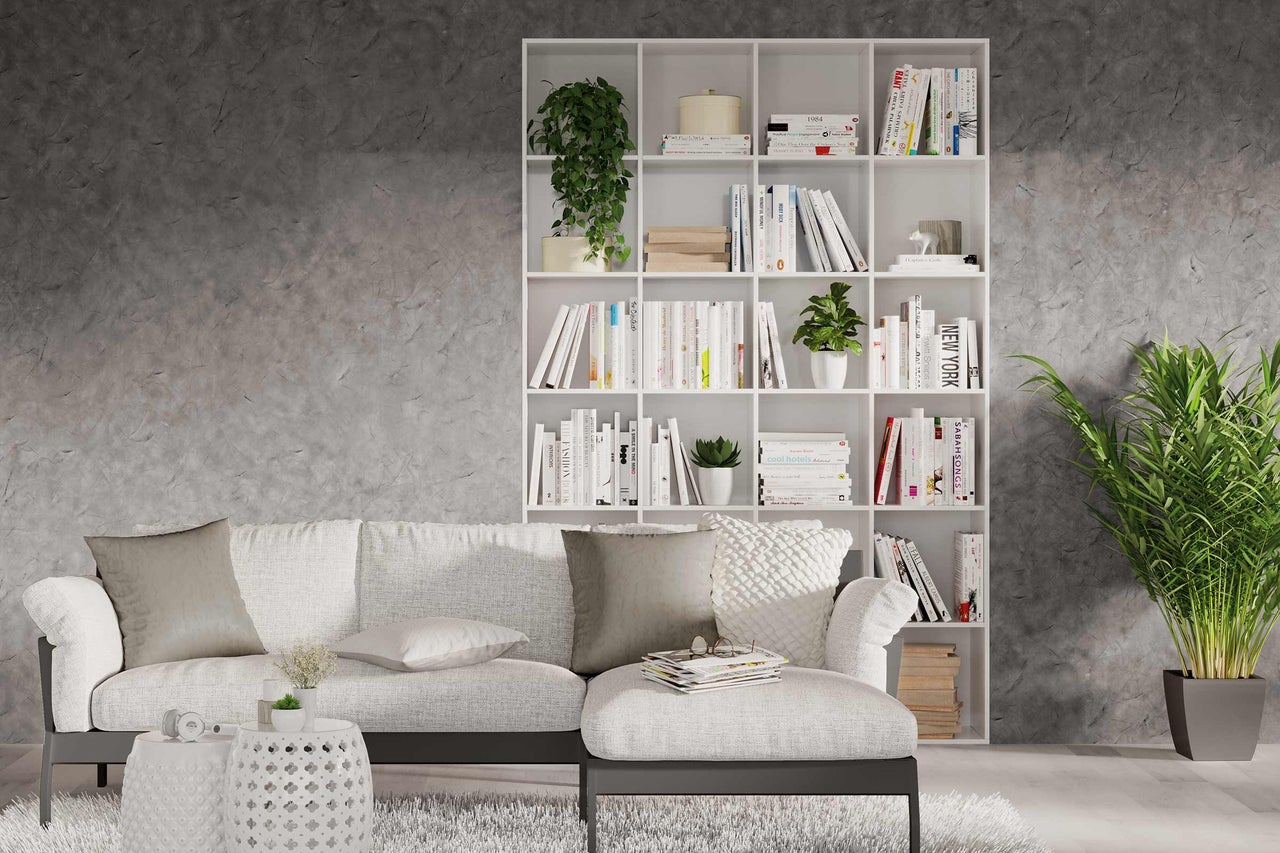 Woonkamer met witte boekenkast, bank en kamerplanten