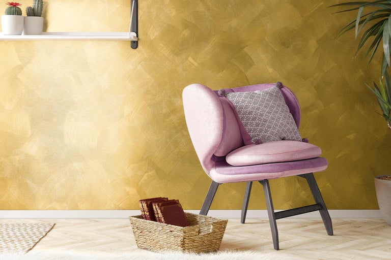 Decoratieve woonsfeer met stoel, kussens en wanddecoratie