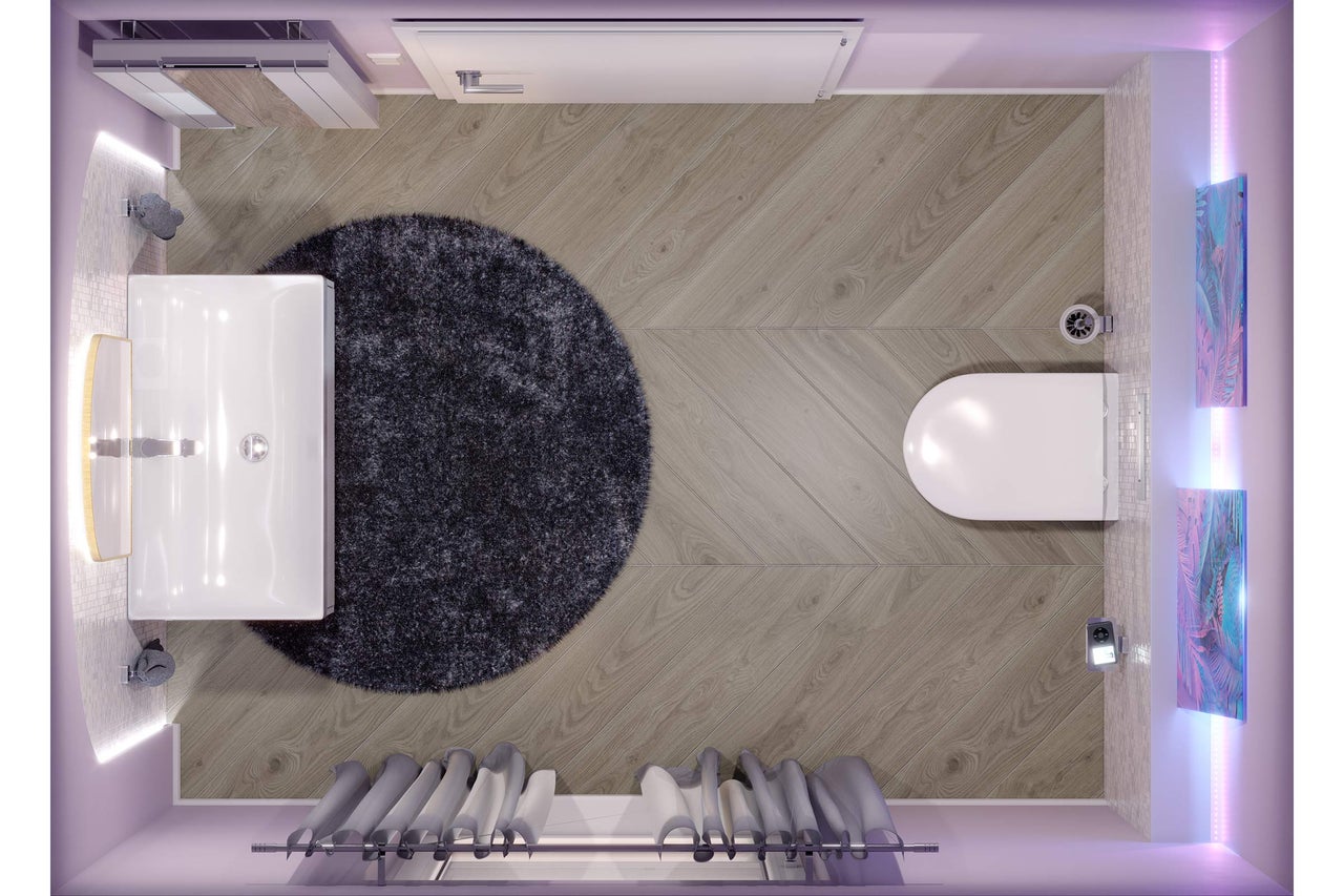 Bovenaanzicht van een moderne badkamer met houtlook vloer in Hongaarse punt, rond tapijt, witte wastafel en hangend toilet.