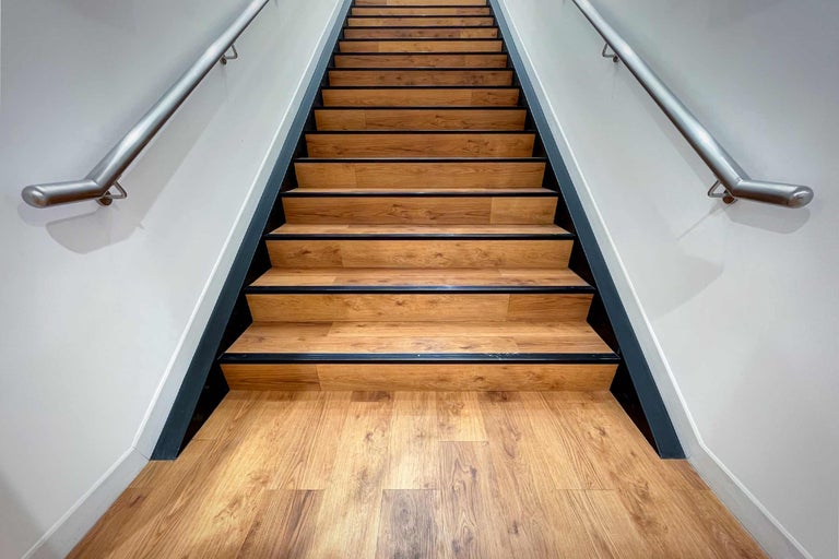 Trap met houten treden en metalen leuning