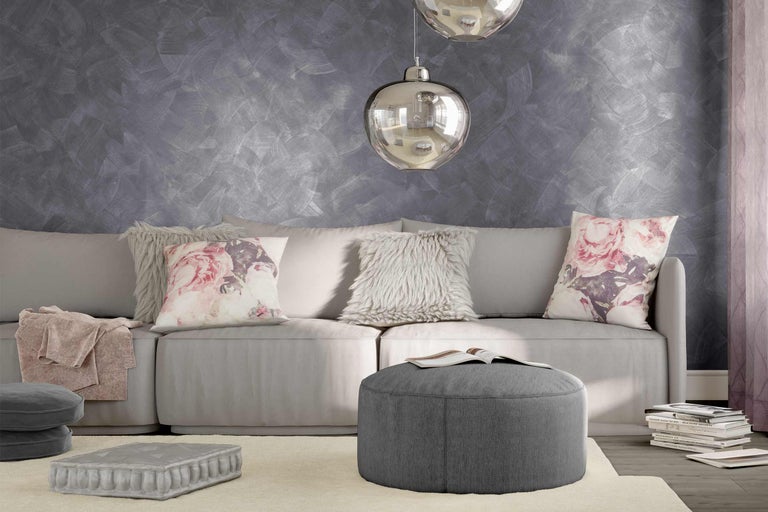 Lichte woonkamer met bank, kussens, kruk en decoratie