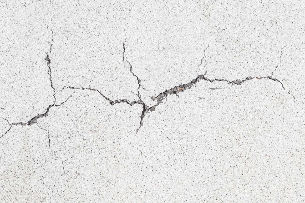 Close-up van een betonnen muur met scheuren
