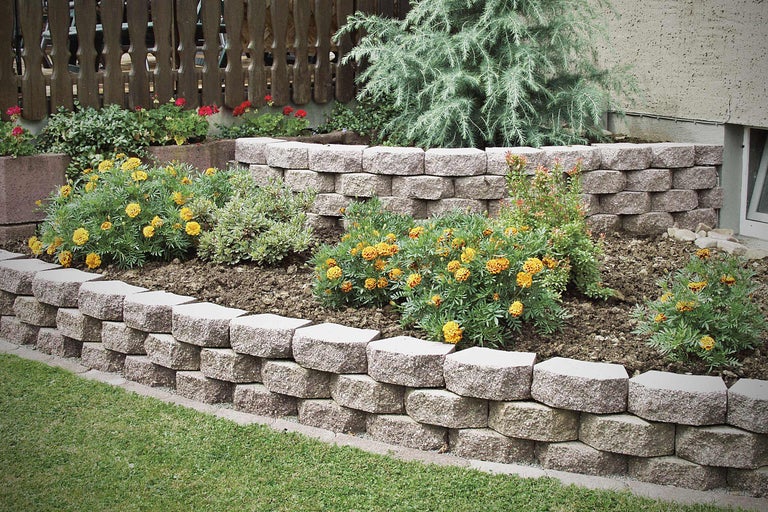 Gelaagde tuin met straatstenen en bloemen