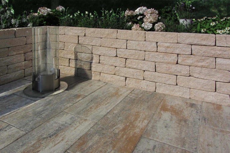 Tuinscene met stenen muur en terrastegels