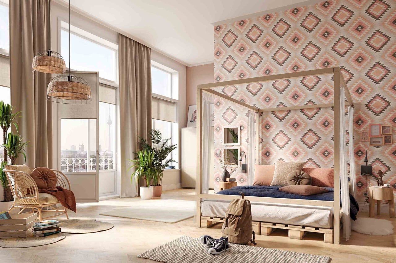 Lichte slaapkamer met hemelbed, behang met motief en rotan meubels