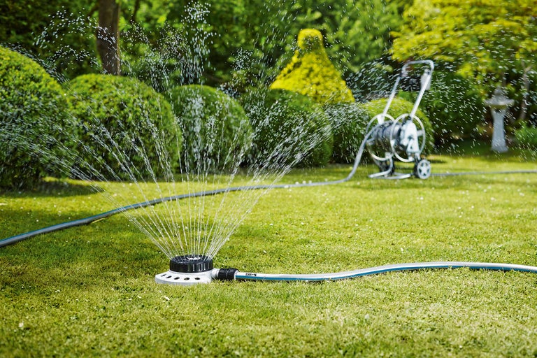 Tuinsproeier besproeit gazon in de tuin.