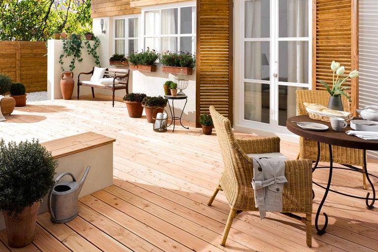 Terras met houten planken, tuinmeubilair en beplanting