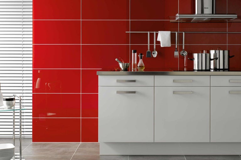 Moderne keuken met rode wandtegels en witte kasten