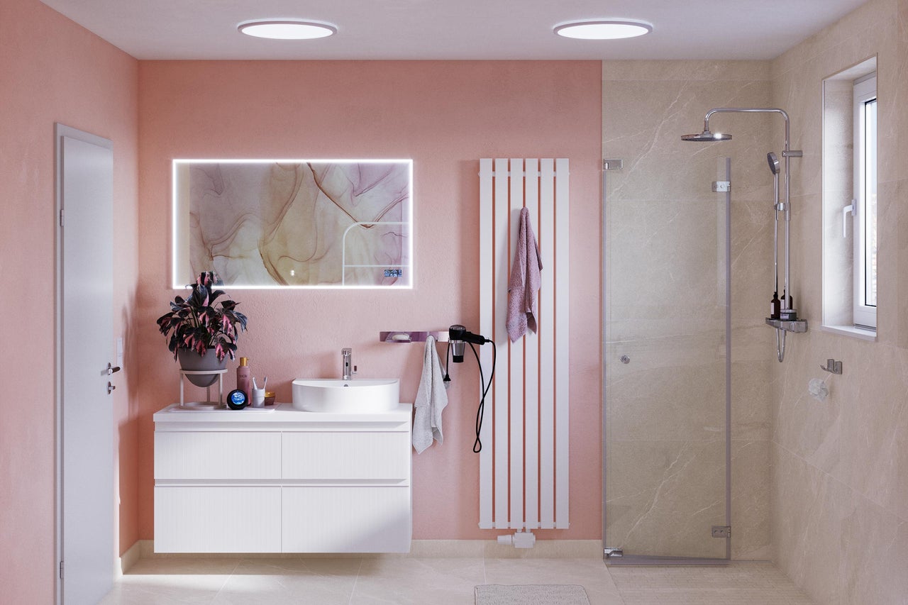 Lichte badkamer met wastafel, spiegel, radiator en douche