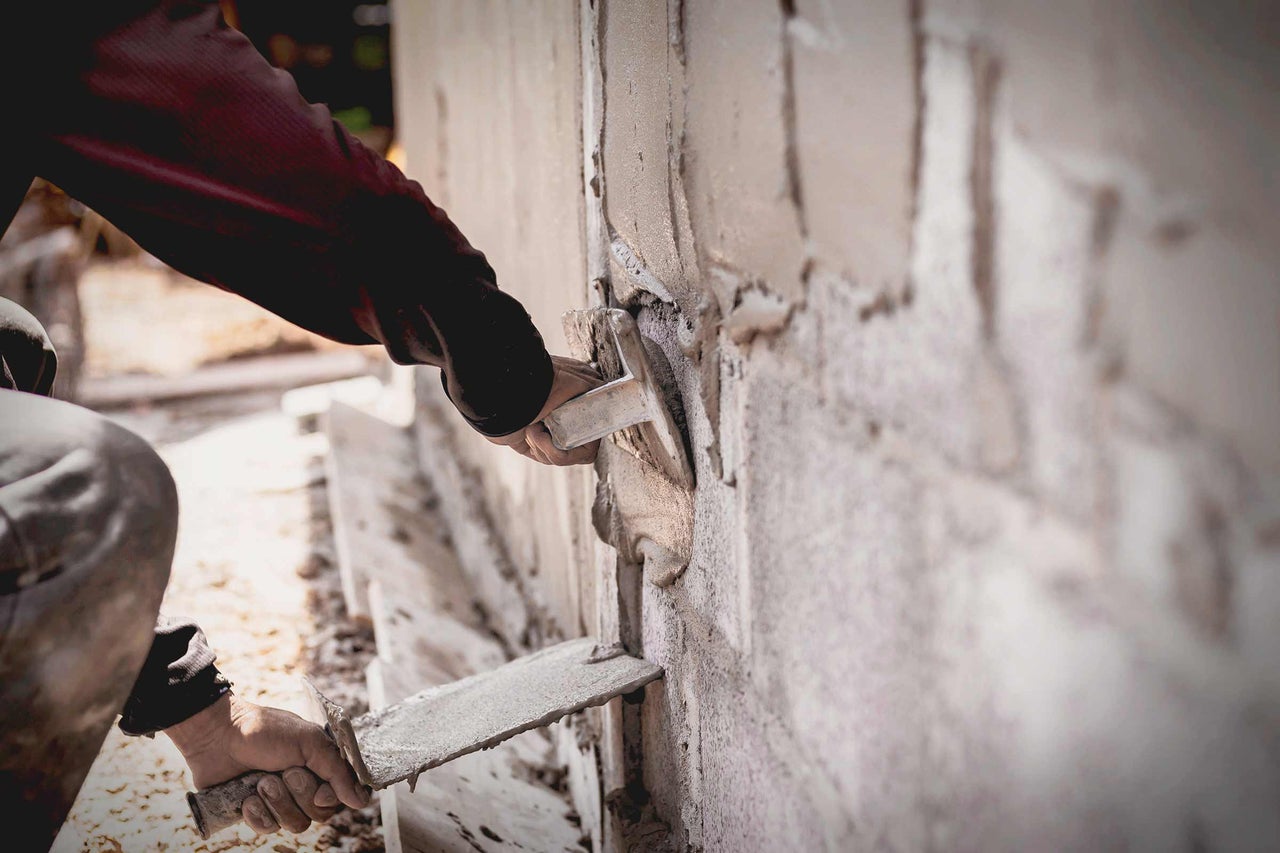 Ambachtsman pleistert een muur met een troffel