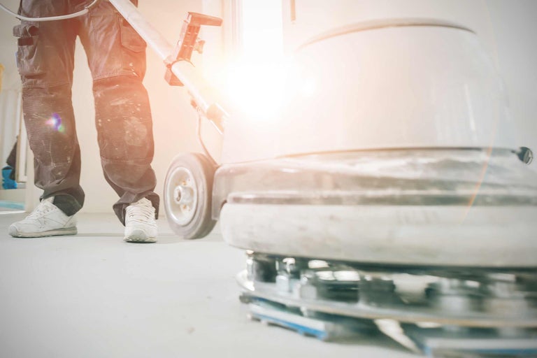 Man bedient een schrobzuigmachine voor vloerbewerking.