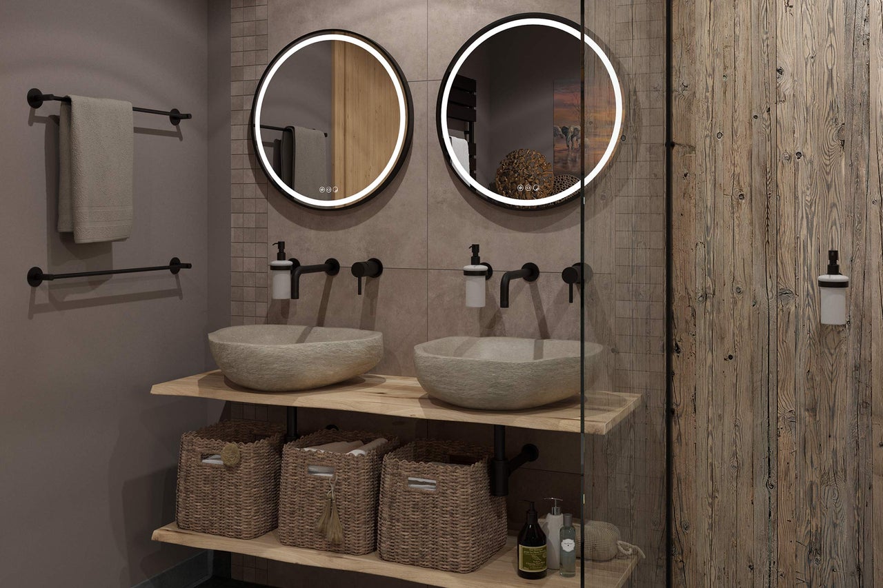 Moderne badkamer met twee ronde led-spiegels, natuurstenen waskommen op houten blad, zwarte kranen en gevlochten manden.