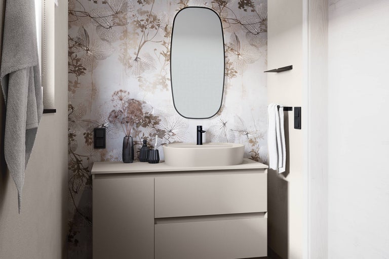 Lichte badkamer met wastafel, spiegel, kraan en bloemenbehang