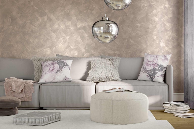 Lichte woonkamer met bank, kussens, poef en decoratieve muur