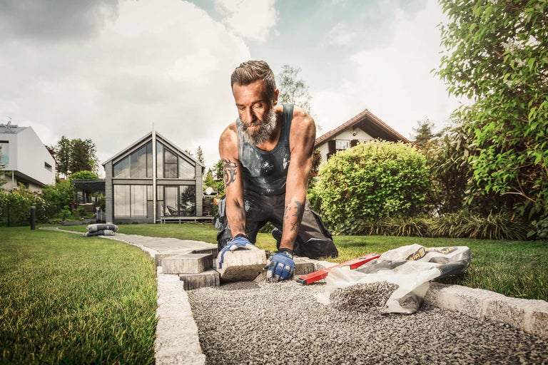 Man legt straatstenen in de tuin