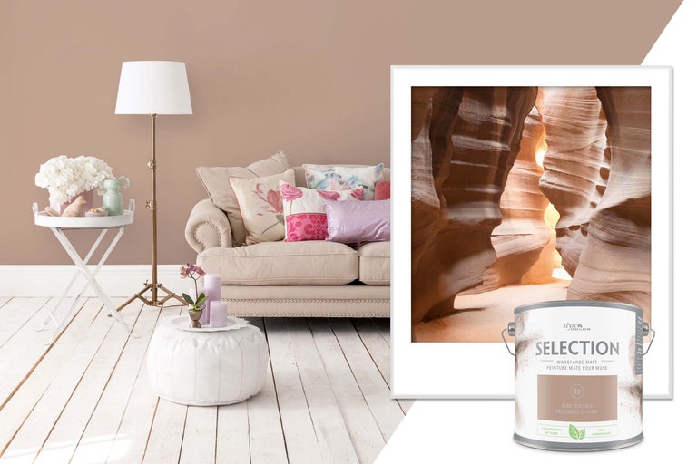 Woonkamer met bank, staande lamp, bijzettafel, kruk, schilderij en blik muurverf